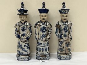 Three Chinese figures of emperors decorated in blue and white. 11½" high.