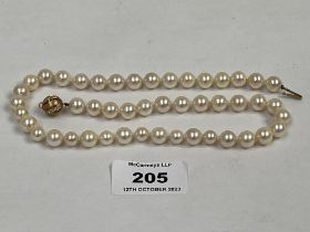 A necklace of knotted pearls with white stone set clasp marked 750. 18" long.