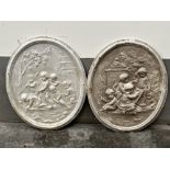 A pair of composition oval plaques, moulded in relief with putti in a garden. 31" high.