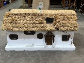 A doll's house with thatched roof. 34" wide, together with a doll's house kit