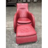 A contemporary style armchair and footstool upholstered in red leather.