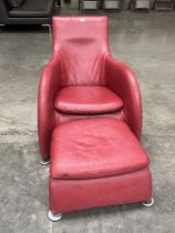 A contemporary style armchair and footstool upholstered in red leather.