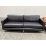 A contemporary style sofa upholstered in black leather. 88" wide.