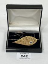 A gold plated leaf brooch/pendant on 9ct necklet chain.