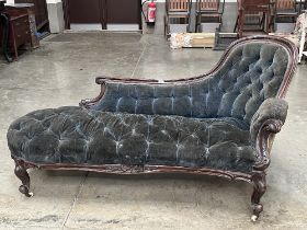 An early Victorian mahogany chaise-longue upholstered in deep buttoned blue velvet. 66" long.