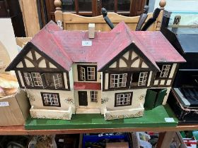 A 1930s Triang doll's house with a quantity of furniture. 27" wide.