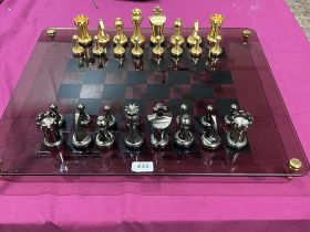 A glass, brass and steel chess set 23½" x 19½".