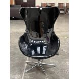 A designer style armchair in black polycarbonate on swivel stand.