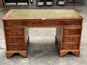 A yew wood veneered pedestal desk with inlet leather top. Of recent manufacture. 54" wide.