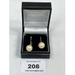 A pair of faux pearl earrings.