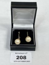 A pair of faux pearl earrings.