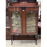An Edward VII mahogany and inlaid display cabinet enclosed by a pair of leaded glazed doors, on