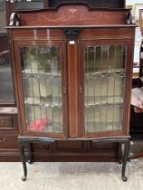 An Edward VII mahogany and inlaid display cabinet enclosed by a pair of leaded glazed doors, on