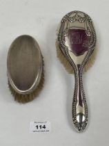 Two silver hair brushes.