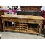 An oak dresser base with three drawers over wine rack. 71" wide