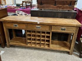 An oak dresser base with three drawers over wine rack. 71" wide