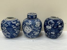 Three Chinese blue and white jars, one with a cover, decorated with prunus on a cracked ice