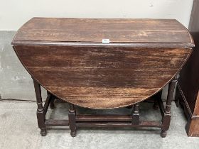 An oak drop leaf table on moulded turned legs and perimeter stretchers. 41" wide.