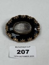 A Victorian mourning brooch with plaited hair. 2" wide.