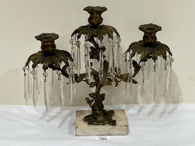 A 19th century ormolu three light lustre candelabrum hung with prismatic drops on marble base.