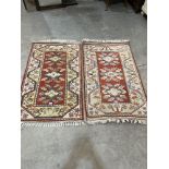 A pair of Turkish red ground rugs. 54" x 32". One faded.