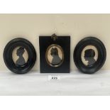 Three portrait silhouettes in ebonised frames.