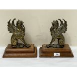 A pair of brass griffins on oak bases. 10" high.