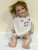 A German Burggrub baby doll with bisque head, sleeping eyes, open mouth and bent limbed