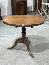 An oak table on tripod support. 33" diam.