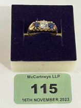 A three stone sapphire and diamond ring. In gold marked 18. 4g gross. Size 0.