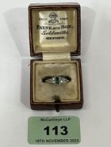 An Art - Deco style emerald and diamond ring. In gold marked 18ct. 3g gross. Size N. Boxed.