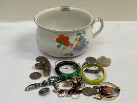 A chamber pot with jewellery, coins and other objects.