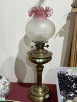 A brass oil lamp with duplex burner and ruby flashed etched shade. 26" high