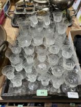 A collection of cut drinking glasses with a carved brass inlaid tray.