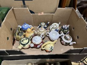 12 miniature ceramic teapots.