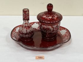 A 19th century Bohemian ruby overlaid glass three piece dressing table set. The jar and cover