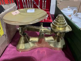 A set of brass weighing scales with weights.