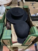 A box of hats, fur stole and a lady's fan.