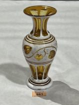 A Bohemian amber glass and white overlaid vase. 8" high.