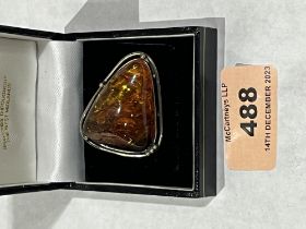 A large amber and silver brooch. 12.8g.