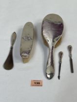 A silver hand mirror and other silver dressing table items.
