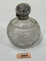 An Edward VII globular cut glass scent bottle with silver mount and repousse lid. Birmingham 1903.