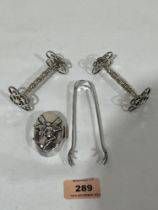 A silver pill box; a pair of white metal knife rests and a white metal sugar bow