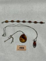 A silver and amber cabochon bracelet and two silver and amber pendants on necklet chains.