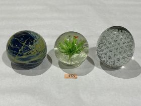 Three large glass paperweights, one by Mdina glassworks.