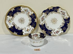 Two Coalport batwing cabinet plates and a bowl, painted with sprays of summer flowers and enriched