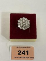 A nineteen stone diamond cluster ring. In white gold marked 18ct. Diameter of setting 19mm, the