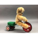 A TEDDY BEAR RIDING A TRICYCLE TOY AND A HERO ACCORDION