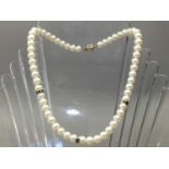 A NINE CARAT GOLD AND SAPPHIRE COSTUME PEARL NECKLACE