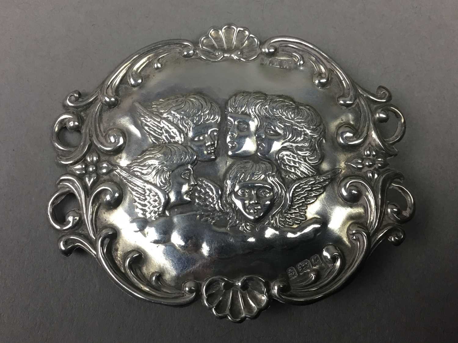 A SILVER BROOCH DEPICTING REYNOLD'S ANGELS, ALONG WITH PLATED BELT AND SPOON